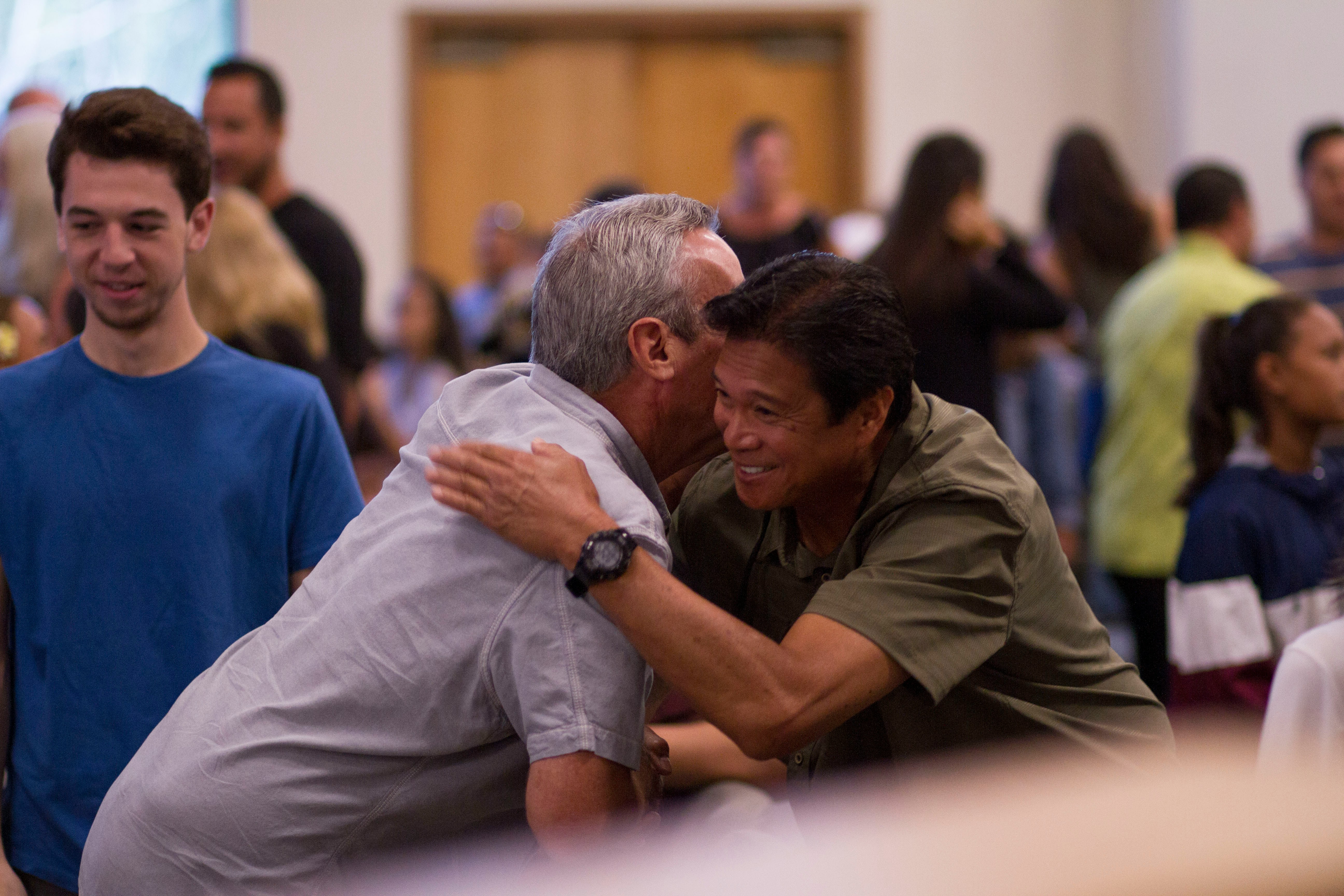 Two men hugging at community event
